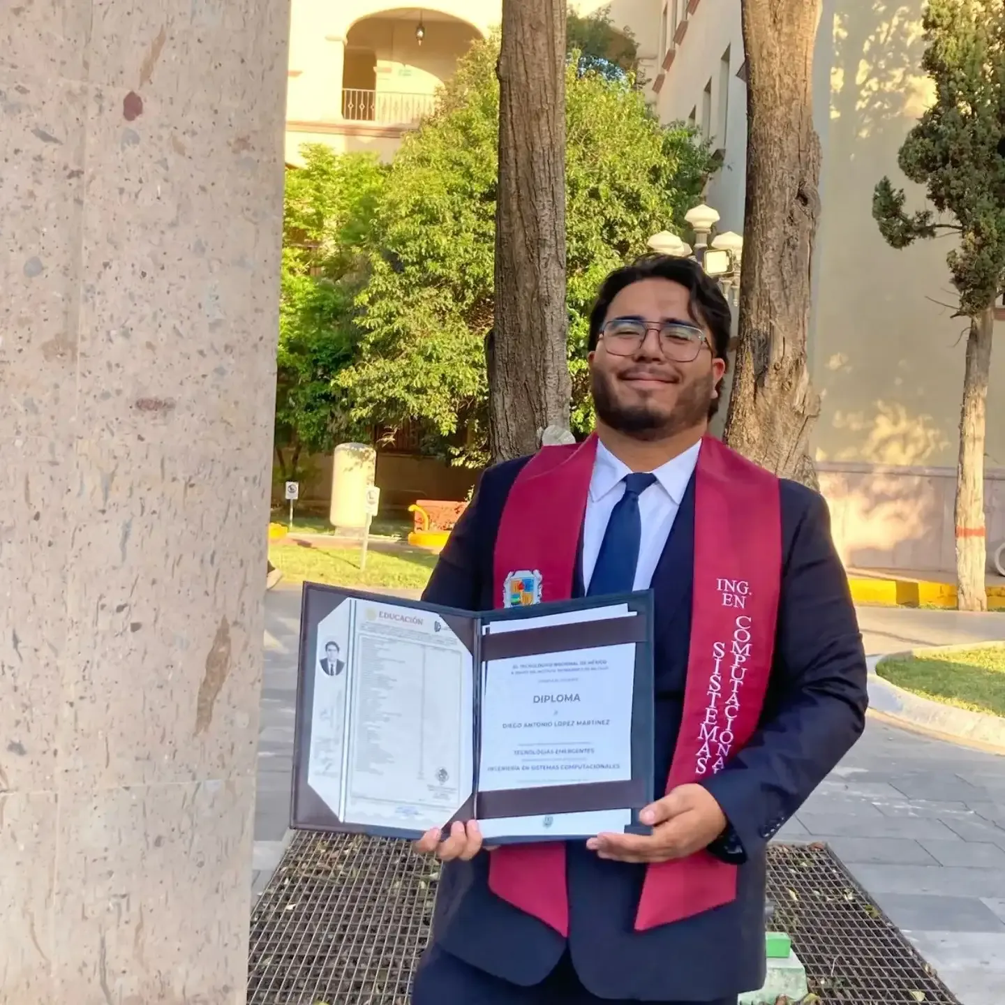 Diego at his graduation holding his diploma